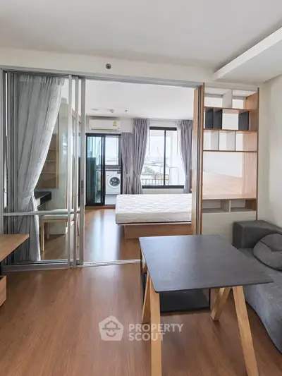 Modern studio apartment with sliding glass doors and wooden flooring