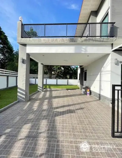 Modern house exterior with spacious driveway and lush green lawn