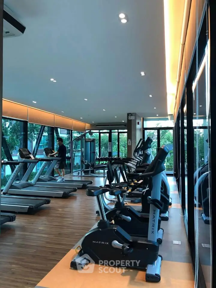 Modern gym with state-of-the-art equipment and large windows offering a scenic view.