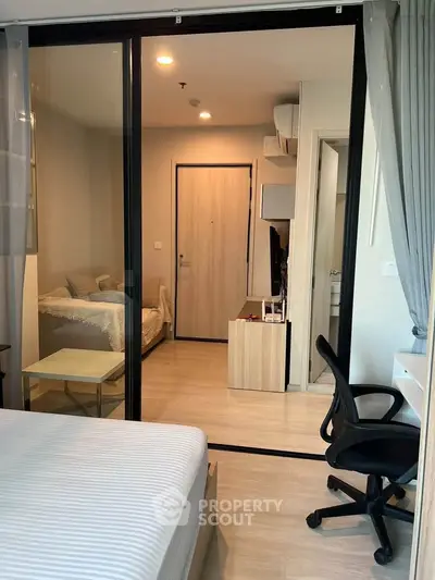 Modern apartment interior with sliding glass doors and cozy bedroom setup