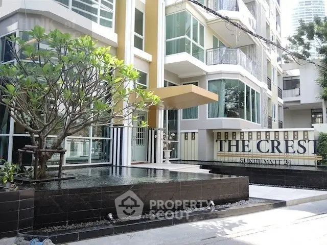 Modern condominium entrance with stylish facade and water feature at The Crest Sukhumvit 34.