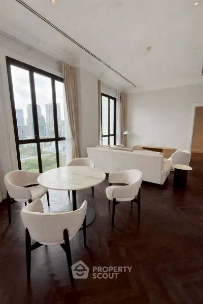 Luxurious living room with city view, elegant furniture, and large windows in a high-rise apartment.