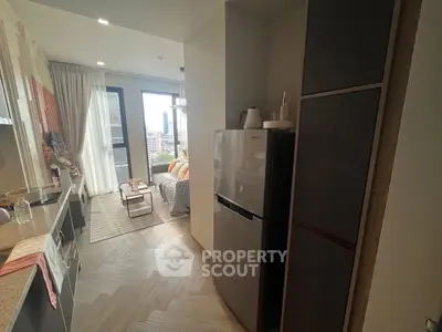 Modern kitchen with open layout leading to cozy living room and balcony view.