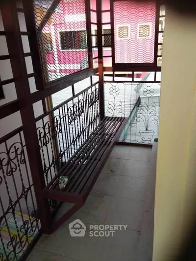 Charming balcony with decorative railing and cozy seating area, perfect for relaxation.