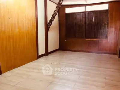 Spacious empty room with wooden accents and large windows, perfect for customization.
