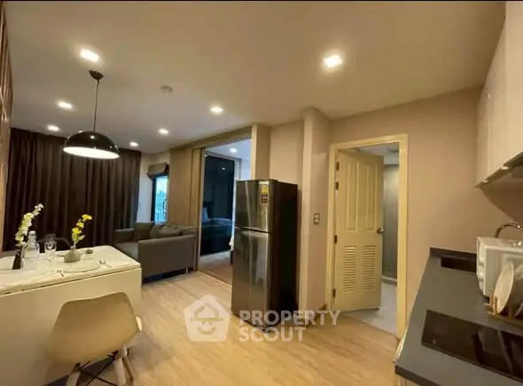 Modern open-plan kitchen and living room with stylish decor and natural lighting.