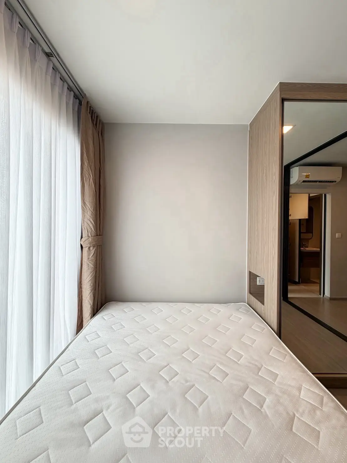 Modern bedroom with large window and minimalist design in a contemporary apartment.