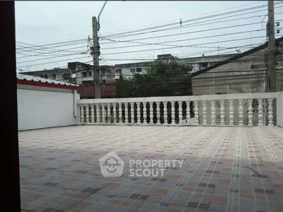 Spacious tiled balcony with urban view, perfect for outdoor relaxation and entertainment.