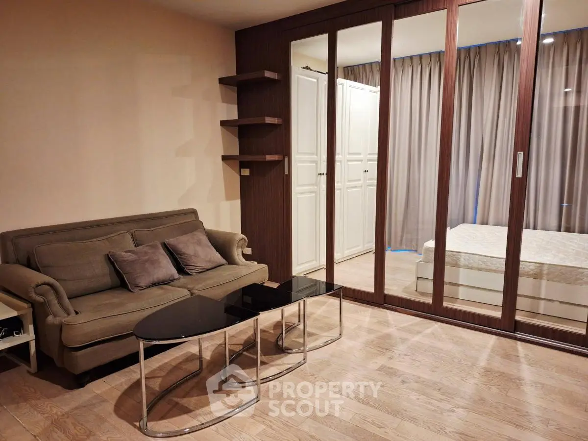 Stylish living room with modern furniture and mirrored wardrobe in a cozy apartment.