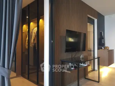 Modern living room with sleek TV setup and stylish walk-in closet
