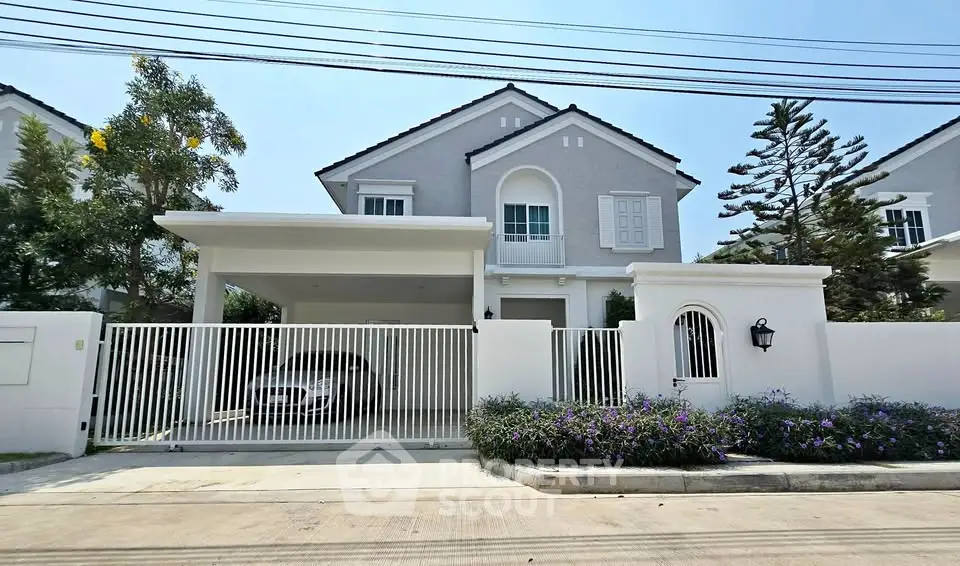 Elegant two-story house with a spacious driveway and lush landscaping in a serene neighborhood.