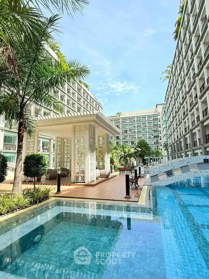 Luxurious apartment complex with stunning pool and elegant outdoor pavilion.