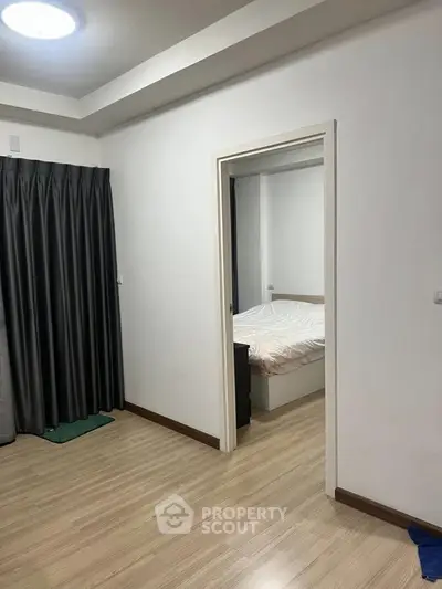 Modern apartment interior with wooden flooring and cozy bedroom view.