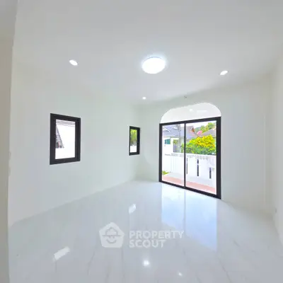 Spacious modern living room with large windows and marble flooring