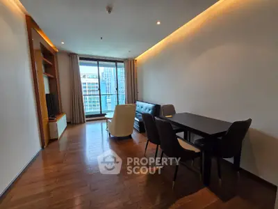 Modern living room with sleek furniture and city view from large windows.