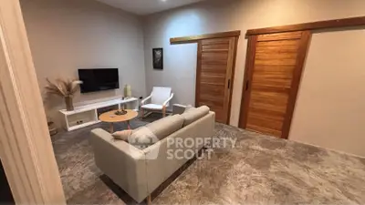 Modern living room with sleek design, featuring a cozy sofa, TV, and stylish sliding wooden doors.