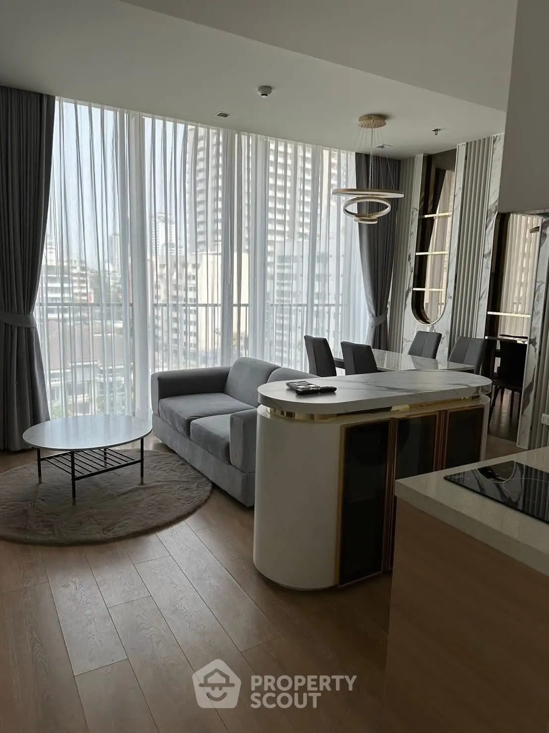 Modern living room with floor-to-ceiling windows and stylish furniture in a high-rise apartment.