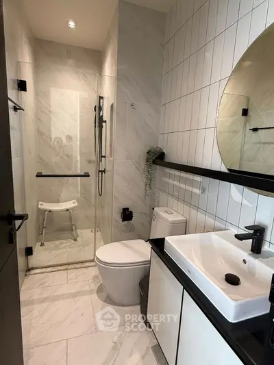 Modern bathroom with sleek design, featuring a glass shower and stylish fixtures.