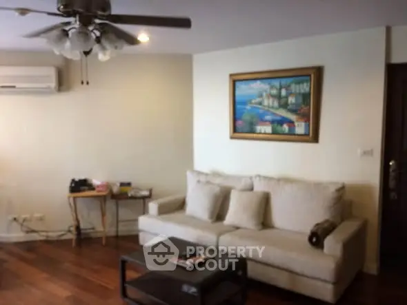 Cozy living room with elegant decor, featuring a plush sofa, stylish coffee table, and wall art, perfect for relaxation.