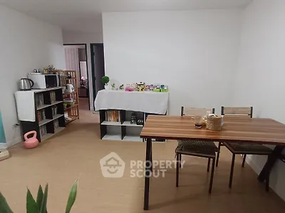 Cozy dining area with wooden table and chairs, adjacent to a compact kitchen setup.