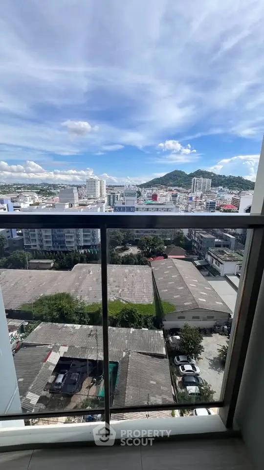 Stunning cityscape view from a high-rise balcony with clear blue skies.
