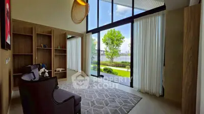 Spacious living room with floor-to-ceiling windows and garden view, featuring elegant decor and natural light.