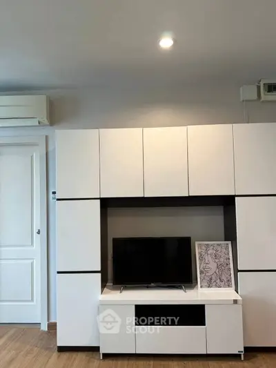 Modern living room with sleek white cabinetry and mounted TV, perfect for contemporary living.