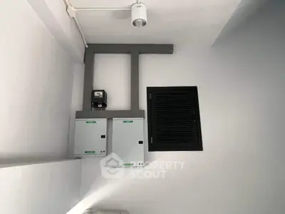 Modern utility room with electrical panels and sleek lighting fixture.