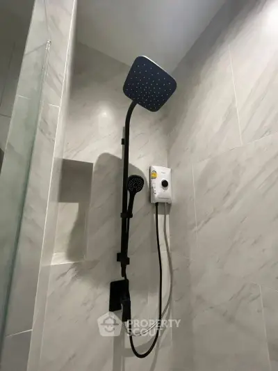 Modern bathroom shower with sleek design and rainfall showerhead in a stylish tiled setting.