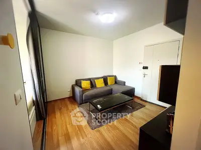 Cozy living room with modern sofa and wooden flooring in a stylish apartment.