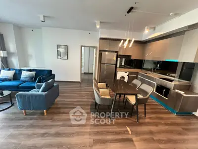 Modern open-plan living room and kitchen with stylish furniture and appliances.