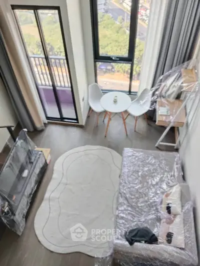 Modern living room with balcony view, stylish furniture, and natural light.
