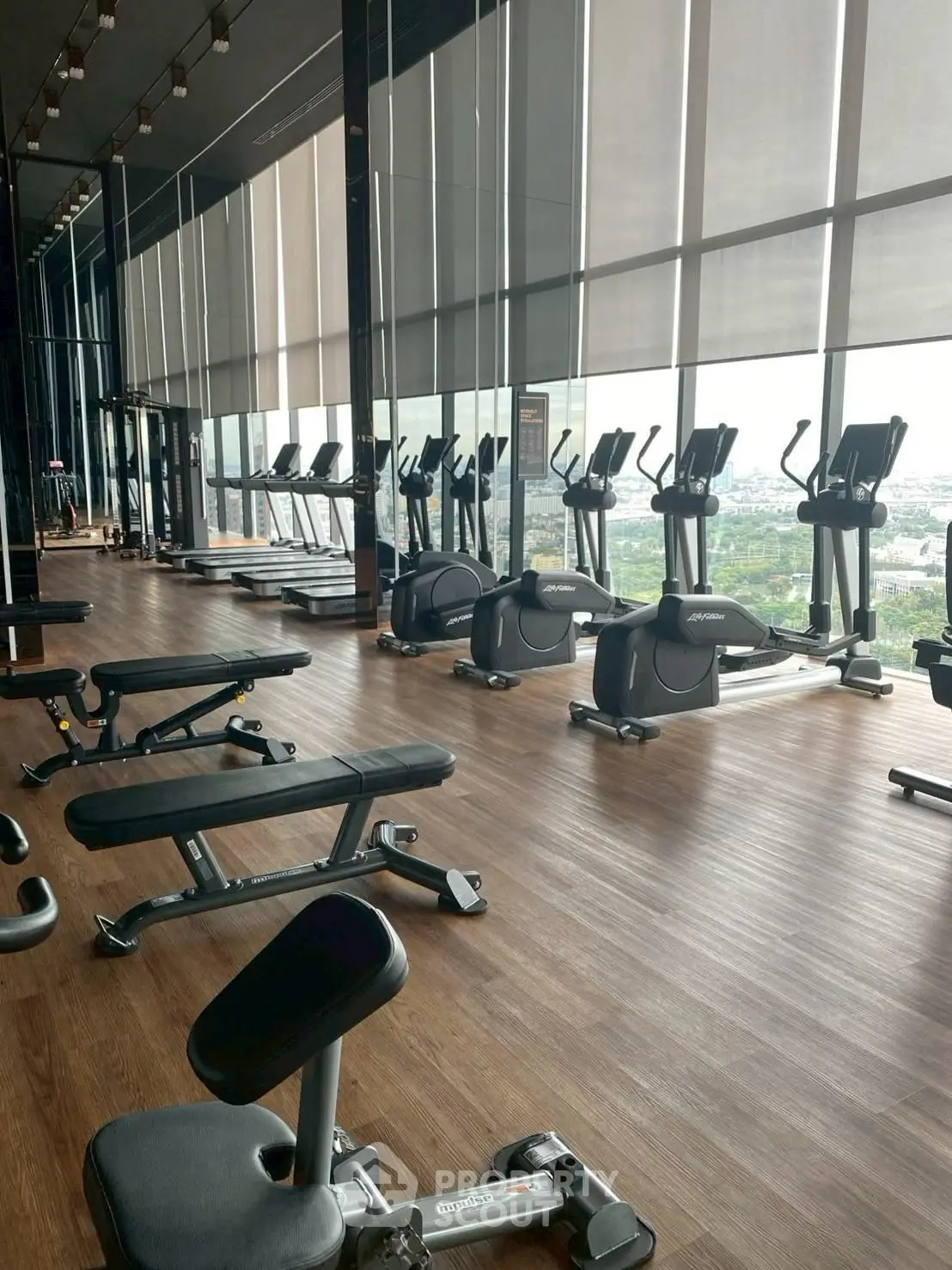 Spacious modern gym with city view and state-of-the-art equipment