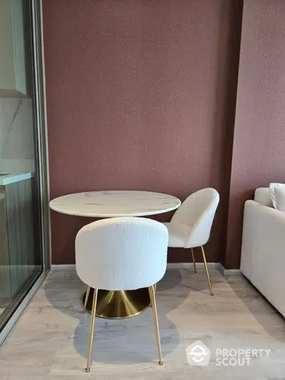 Stylish modern dining area with elegant round table and plush chairs