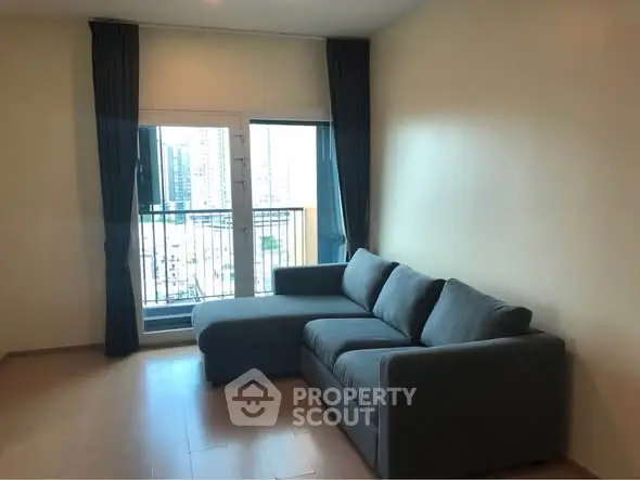 Modern living room with stylish sofa and city view balcony, perfect for urban living.