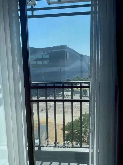 Charming balcony view with modern architecture and clear blue sky.