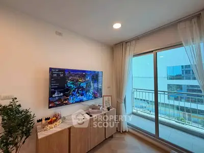 Modern living room with wall-mounted TV and balcony view in a stylish apartment.