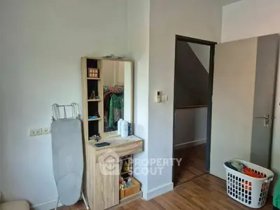 Cozy bedroom with wooden flooring and modern vanity, perfect for a stylish living space.