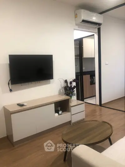 Modern living room with wall-mounted TV and sleek furniture in a stylish apartment.