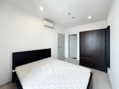 Spacious modern bedroom with minimalist design and ample natural light.