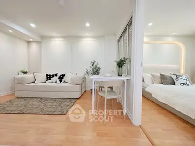 Modern open-concept living room and bedroom with stylish decor and cozy ambiance.