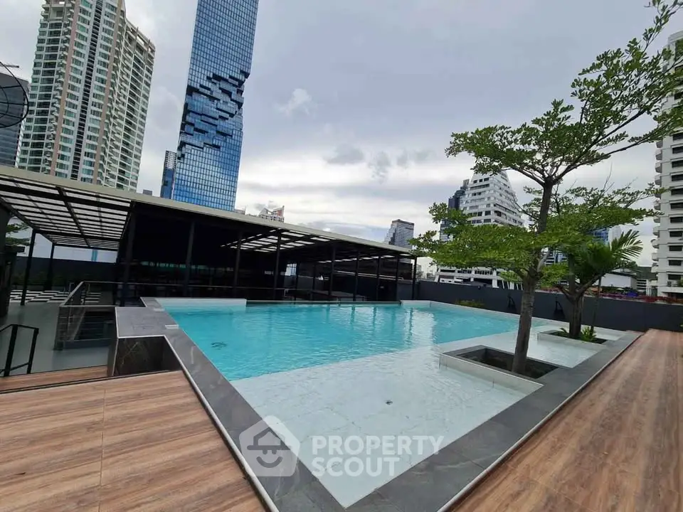 Luxurious rooftop pool with stunning cityscape views in modern high-rise building.
