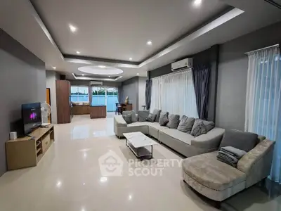 Spacious modern living room with elegant sectional sofa and open layout, perfect for entertaining.