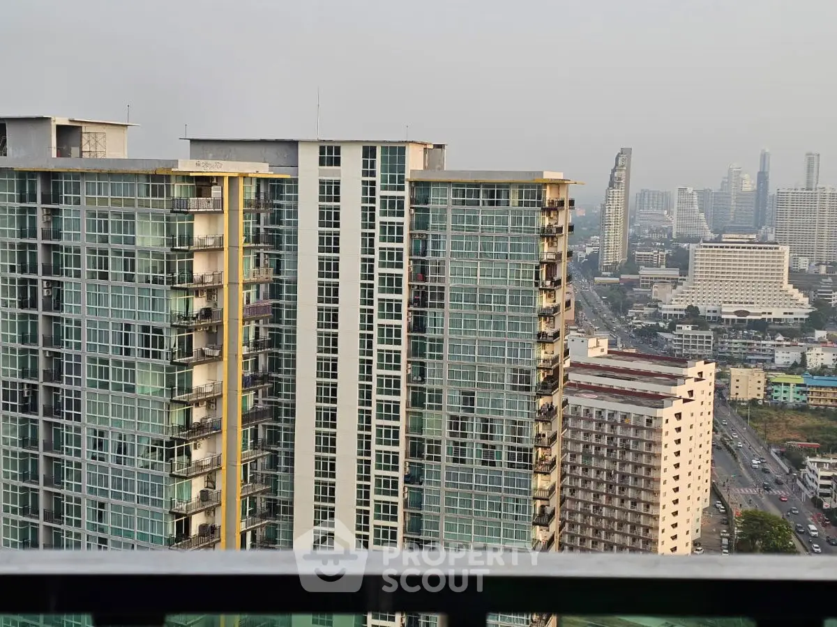 Stunning cityscape view from high-rise balcony overlooking urban skyline.