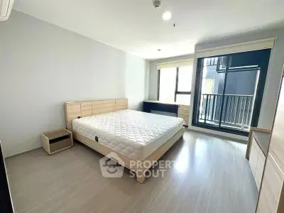 Spacious modern bedroom with large window and minimalist design, featuring a comfortable bed and sleek flooring.