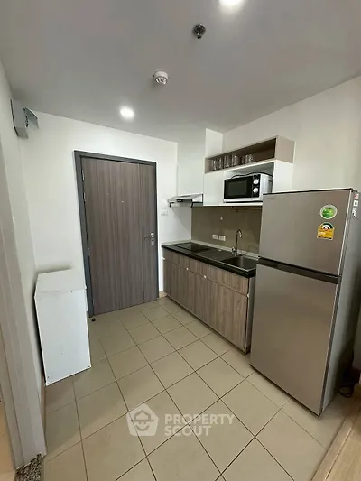 Modern kitchen with sleek appliances and closed layout in a contemporary apartment.