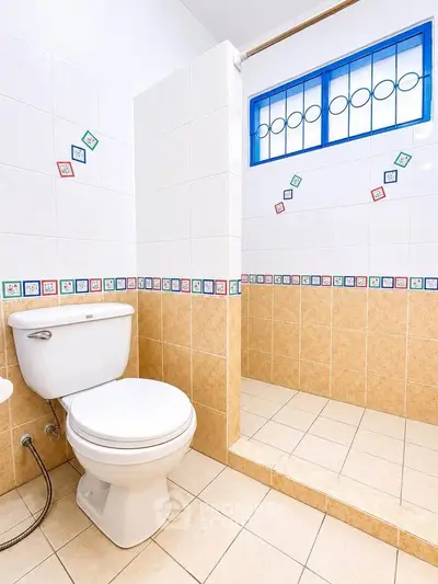 Bright and clean bathroom with tiled shower and decorative accents.