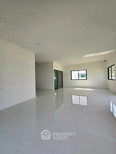 Spacious modern living room with glossy white tiles and large windows