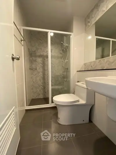 Modern bathroom with glass shower and sleek fixtures in a contemporary home.