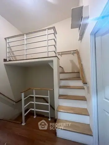 Modern staircase with wooden steps and white railing in a stylish home interior